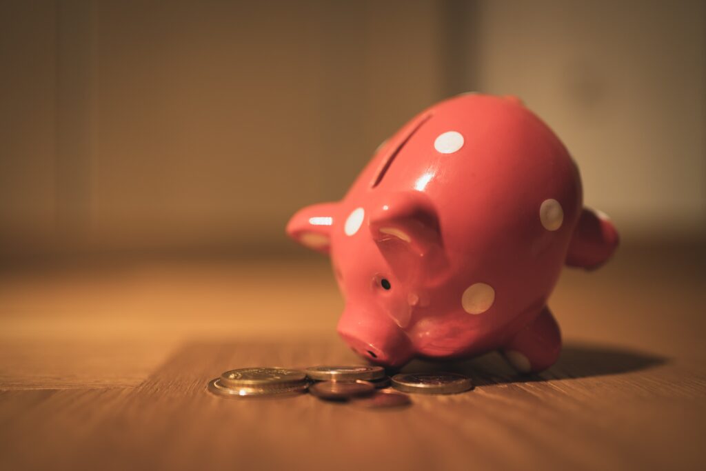 Red piggy bank with coins around it