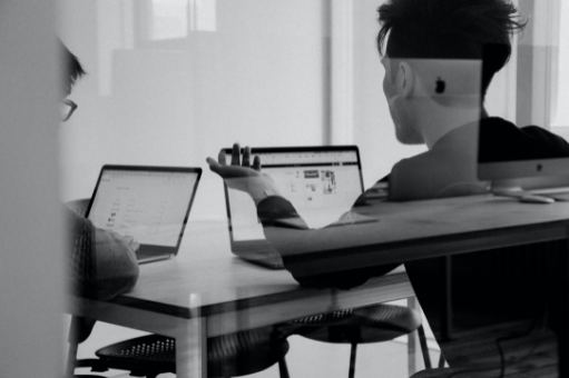 Black and white image of men at laptops